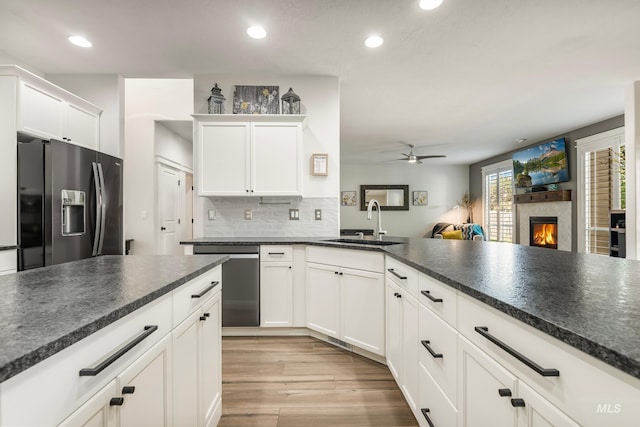 2679 S Tristram Way, Meridian, ID 83642 - kitchen featuring appliances with stainless steel finishes, a sink, ceiling fan, light wood-style floors, and dark countertops