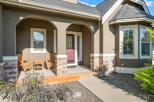 2679 S Tristram Way, Meridian, ID 83642 - doorway to property with stone siding, a shingled roof, a porch, and stucco siding