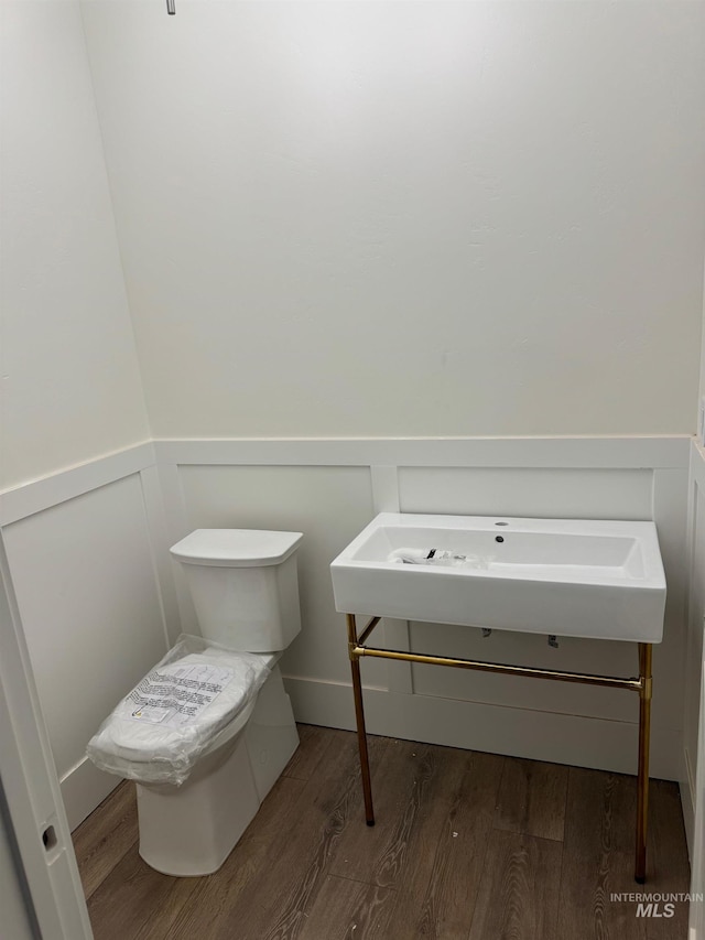 bathroom featuring hardwood / wood-style flooring and toilet