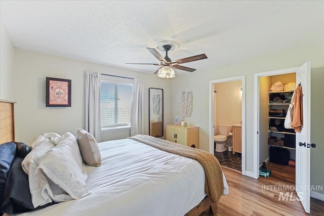 3318 E Princess Amy Ct, Nampa, ID 83687 - bedroom with light wood-type flooring, a walk in closet, a closet, ensuite bath, and a textured ceiling