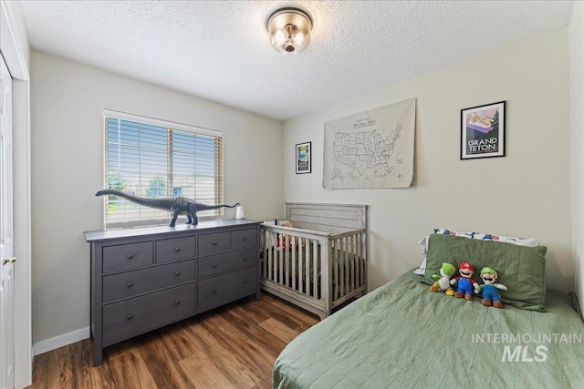 3318 E Princess Amy Ct, Nampa, ID 83687 - bedroom featuring dark wood-style flooring, a textured ceiling, and baseboards