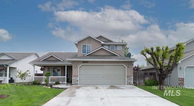 craftsman house with covered porch, driveway, a garage, fence, and a front lawn