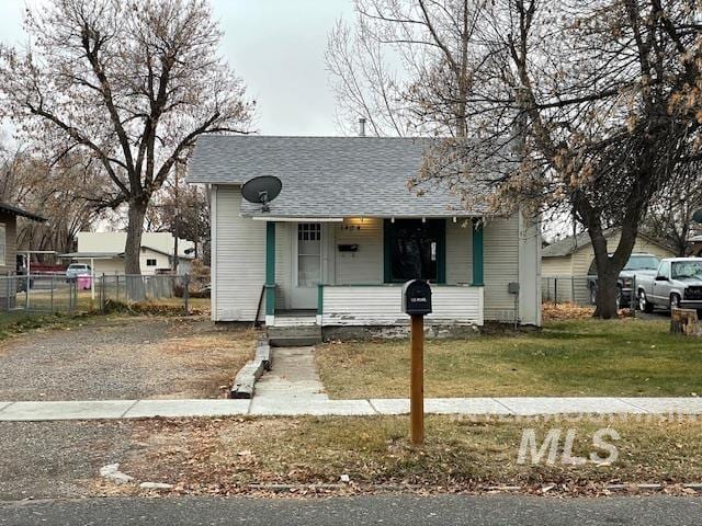 bungalow-style home with covered porch and a front yard