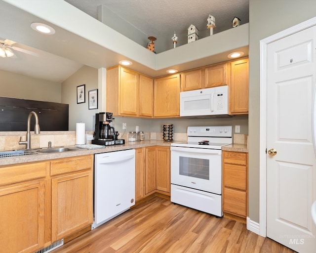 kitchen featuring white appliances, light brown cabinets, light countertops, and a sink