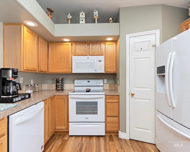 kitchen featuring light wood-type flooring, light brown cabinetry, recessed lighting, white appliances, and light countertops