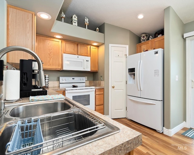 kitchen with recessed lighting, light wood-style flooring, white appliances, and light countertops