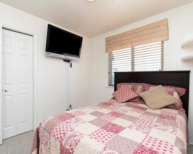 bedroom featuring a closet, a textured ceiling, and carpet floors