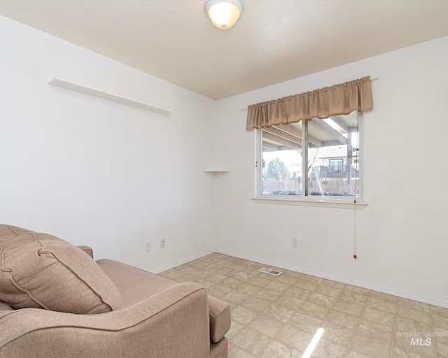 sitting room featuring visible vents, light floors, and baseboards