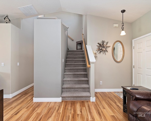 entrance foyer with visible vents, light wood-style flooring, stairs, and baseboards