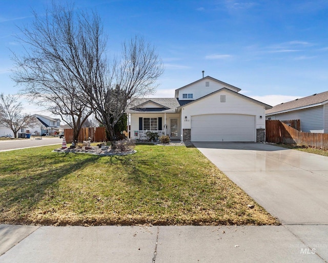 traditional-style house featuring a garage, a front yard, driveway, and fence