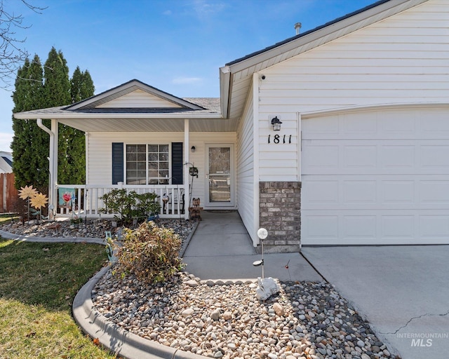 view of front of house with stone siding, a porch, and an attached garage