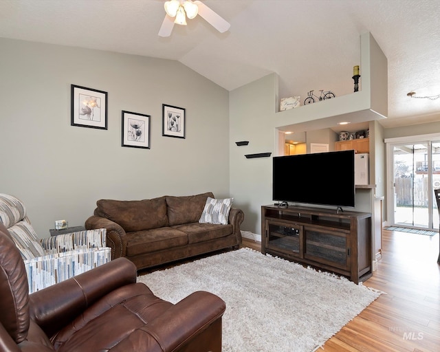 living room featuring vaulted ceiling, light wood-style flooring, a ceiling fan, and baseboards