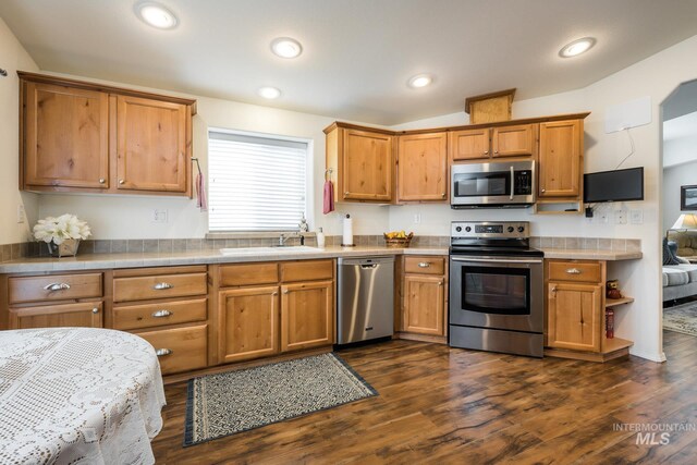 421 Curtis Rd Unit 120, Boise, ID 83705 - kitchen with stainless steel appliances, a sink, dark wood-style flooring, recessed lighting, and brown cabinetry