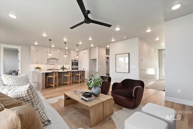 living room with ceiling fan and light hardwood / wood-style floors