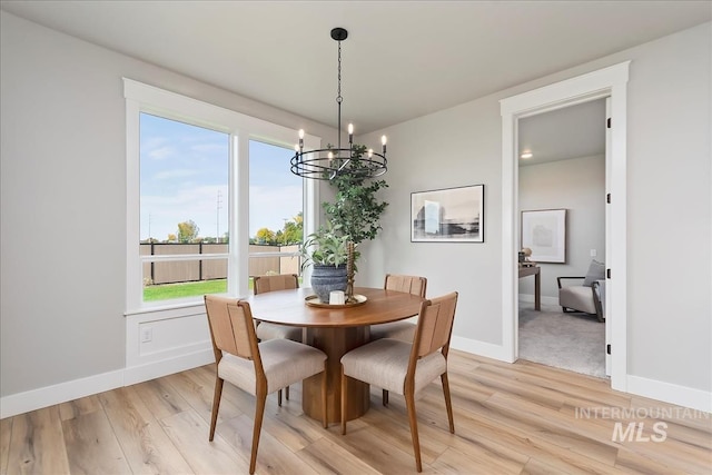 dining space featuring a notable chandelier and light hardwood / wood-style flooring