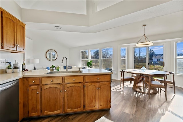 kitchen with dishwasher, hanging light fixtures, kitchen peninsula, hardwood / wood-style flooring, and sink