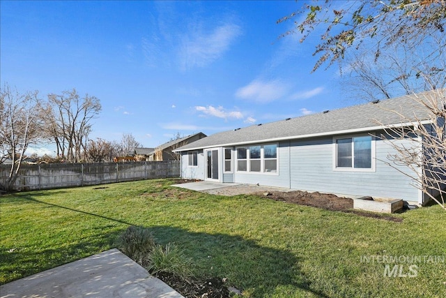 rear view of house with a patio and a yard