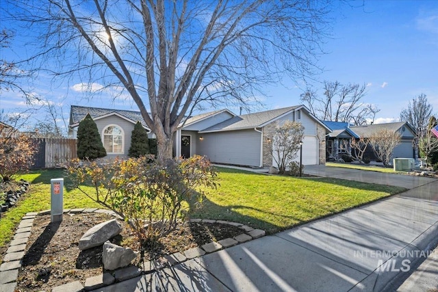 ranch-style home featuring central air condition unit, a front yard, and a garage