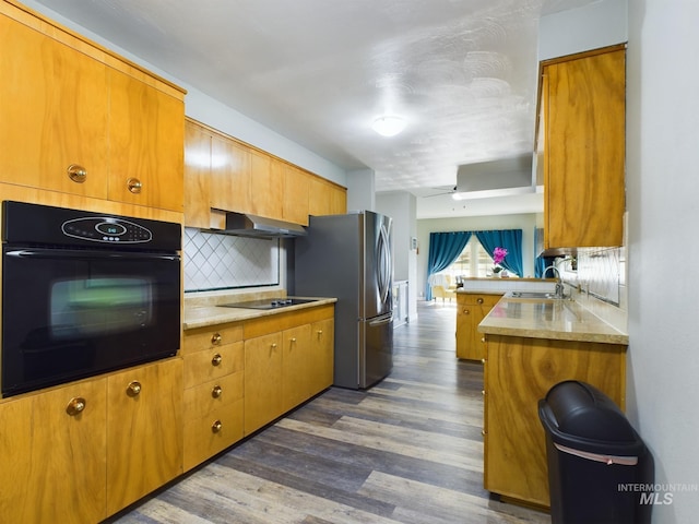 kitchen with backsplash, sink, black appliances, dark hardwood / wood-style floors, and kitchen peninsula