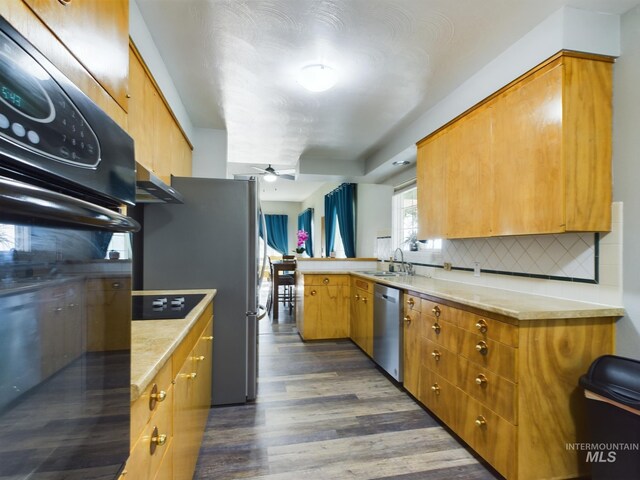 kitchen featuring decorative backsplash, ceiling fan, kitchen peninsula, dark wood-type flooring, and stainless steel dishwasher