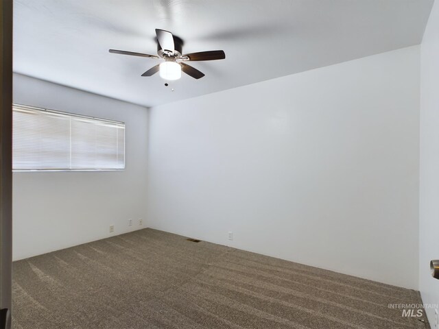 carpeted spare room with ceiling fan