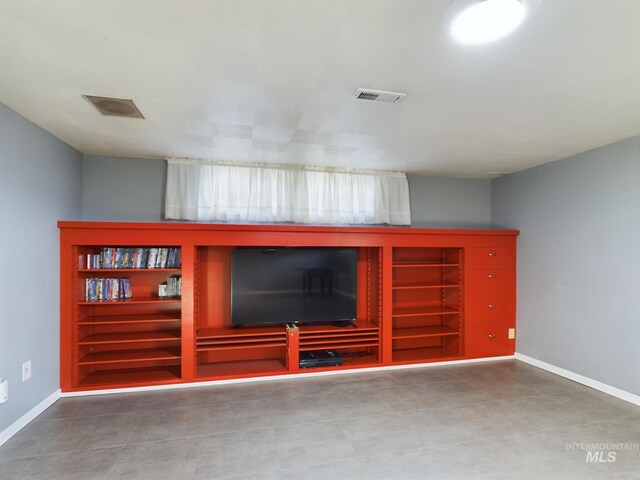 unfurnished living room with tile patterned floors and built in shelves