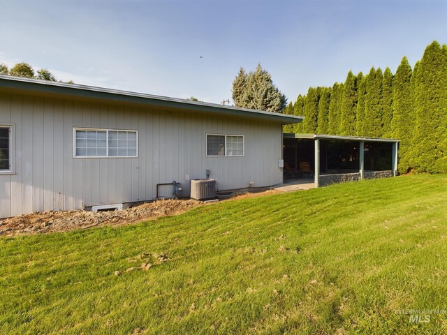 rear view of property with a yard, a sunroom, and cooling unit