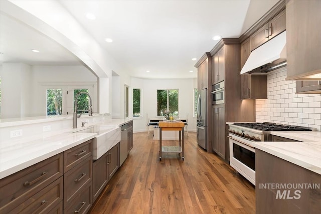 1512 E Rivers End Ct, Eagle, ID 83616 - kitchen with stainless steel appliances, under cabinet range hood, decorative backsplash, dark wood-style flooring, and recessed lighting
