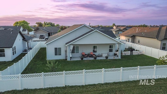 150 Cayuse Creek Dr, Kimberly, ID 83341 - back of house at dusk featuring a residential view, a fenced backyard, and a patio area