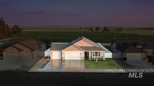 150 Cayuse Creek Dr, Kimberly, ID 83341 - ranch-style house with an attached garage, driveway, stone siding, and a view of countryside