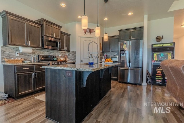 150 Cayuse Creek Dr, Kimberly, ID 83341 - kitchen with appliances with stainless steel finishes, stone counters, dark wood-type flooring, backsplash, and decorative light fixtures