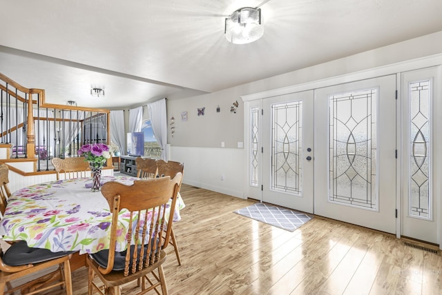 dining area with light hardwood / wood-style floors and french doors