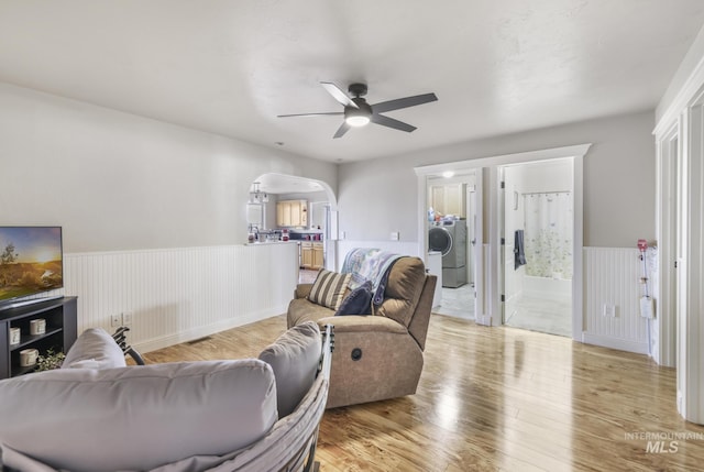 living room with ceiling fan, washer / dryer, and light wood-type flooring