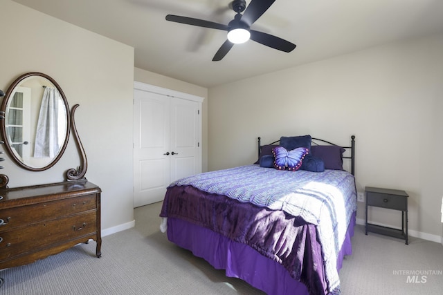 bedroom featuring light colored carpet, a closet, and ceiling fan