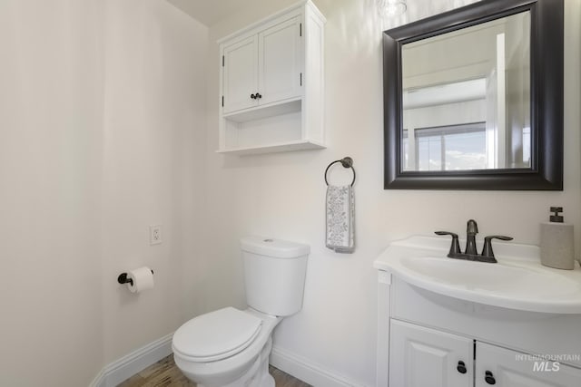 bathroom with hardwood / wood-style flooring, vanity, and toilet