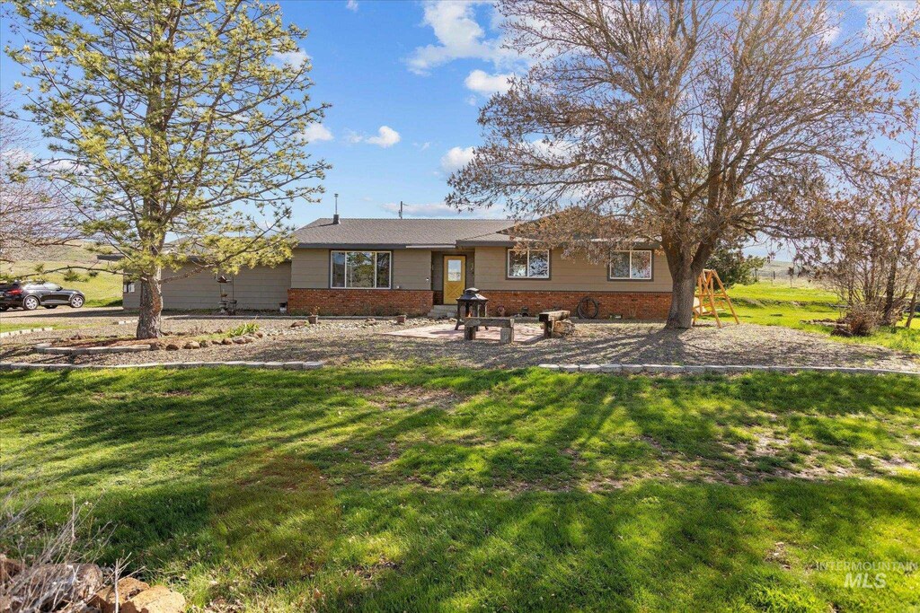 ranch-style home with brick siding and a front yard