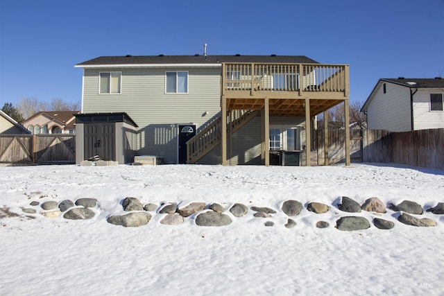 snow covered back of property featuring a deck