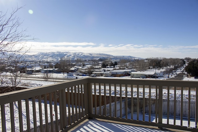 snow covered deck with a mountain view