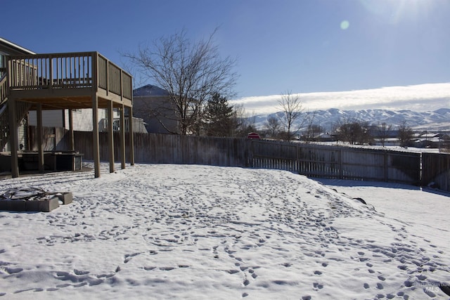 yard covered in snow featuring a mountain view