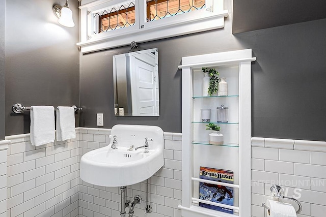 bathroom with a sink, tile walls, and wainscoting