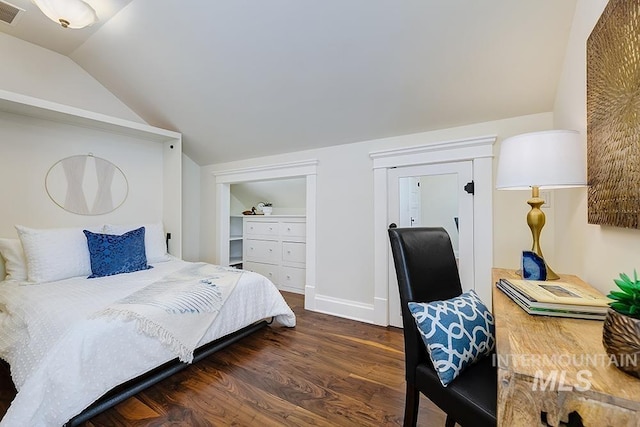 bedroom featuring visible vents, baseboards, wood finished floors, and vaulted ceiling