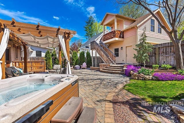 exterior space featuring stairs, a hot tub, and fence