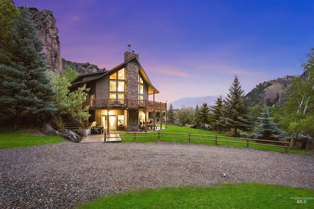 9 Autumn Blaze Ln, Salmon, ID 83467 - rear view of house featuring a deck with mountain view, a chimney, a patio area, and gravel driveway