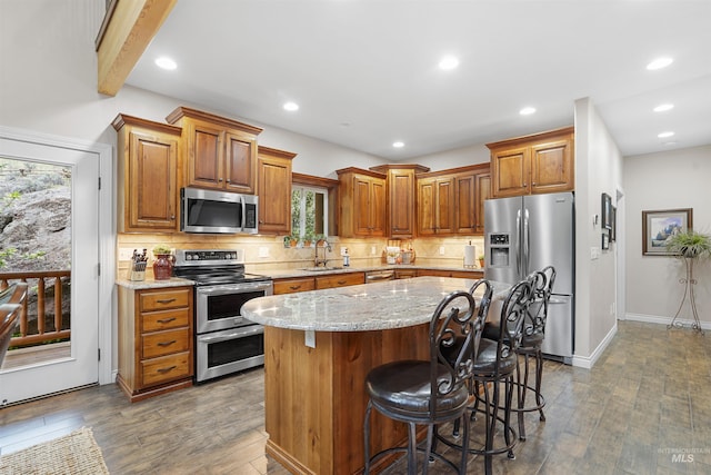 9 Autumn Blaze Ln, Salmon, ID 83467 - kitchen featuring stainless steel appliances, a sink, backsplash, light stone counters, and wood finished floors