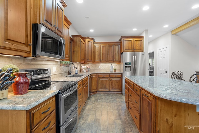 9 Autumn Blaze Ln, Salmon, ID 83467 - kitchen with stainless steel appliances, wood finished floors, brown cabinetry, a sink, and light stone countertops