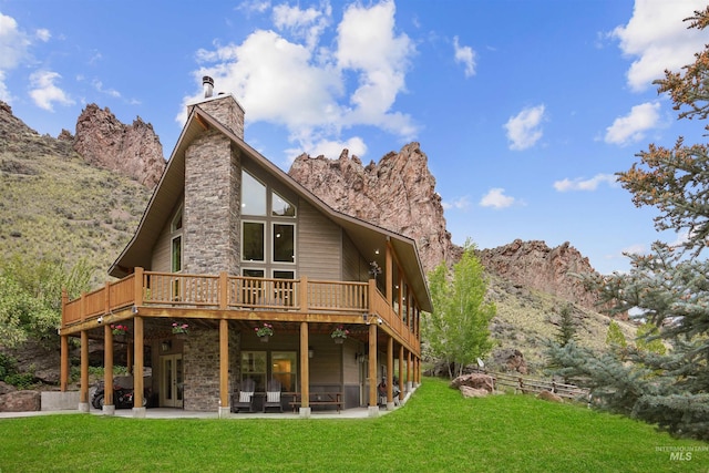 9 Autumn Blaze Ln, Salmon, ID 83467 - back of house featuring a deck with mountain view, a yard, a chimney, and a patio