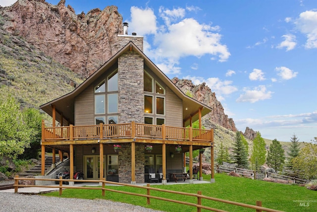 9 Autumn Blaze Ln, Salmon, ID 83467 - back of property featuring a deck with mountain view, stairway, a patio area, stone siding, and a chimney