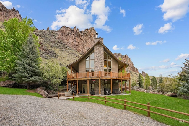 9 Autumn Blaze Ln, Salmon, ID 83467 - rear view of house featuring a deck, stairs, stone siding, a patio, and a chimney
