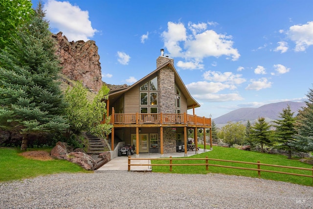 9 Autumn Blaze Ln, Salmon, ID 83467 - back of house featuring stone siding, a deck with mountain view, a patio, stairs, and a chimney