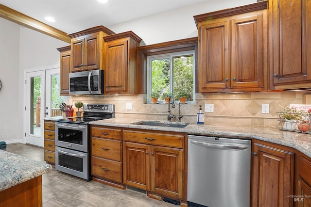 9 Autumn Blaze Ln, Salmon, ID 83467 - kitchen with appliances with stainless steel finishes, a sink, decorative backsplash, light stone counters, and plenty of natural light